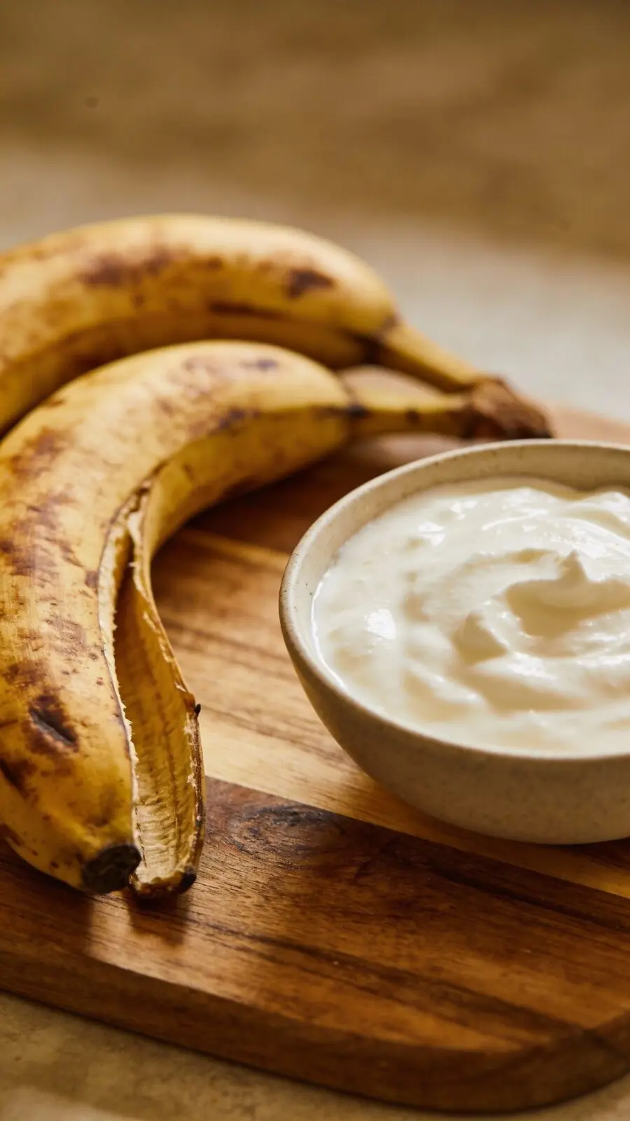Overripe bananas and Greek yogurt on wooden board