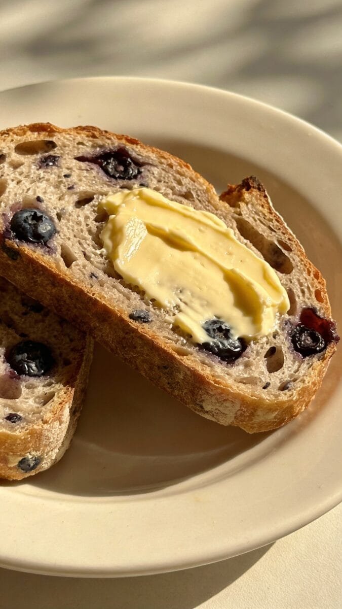 sliced blueberry sourdough with butter on plate